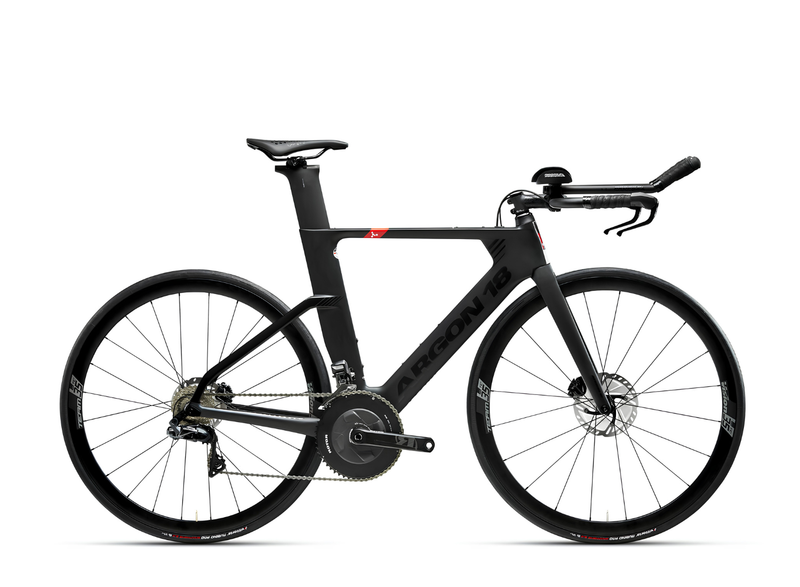 A black carbon fiber time trial bicycle with aerodynamic drop handlebars, a sleek integrated seat post, and disc brakes, shown from a side profile on a white background.
